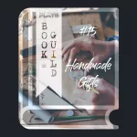 A book icon with a photo that shows an art desk with art utensils and the hands of a human who's crafting a sigil/stamp for a letter. Photo by Annie Spratt from Unsplash. A bookmark on the left side of the book, with the Pending Plays logo at the top and "Book Guild" in vertical format below. On the right of the book it says "#15 Handmade Gifts" in a bold font with dripping liquid.