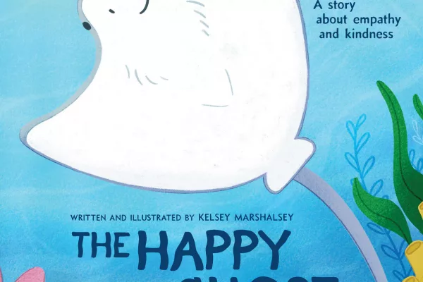 The cover of "The Happy Ghost" by Kelsey Marshalsey. A cownose stingray with their white underside facing to the viewer. They're happily swimming underwater with plants on the border of the image.